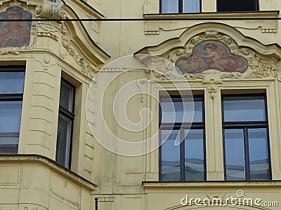 Neoclassic style paintings over the windows of an ancient building of Prague in Czech Republic. Editorial Stock Photo