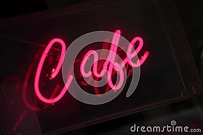 Neon cafe sign, vivid pink, illuminated at night Stock Photo