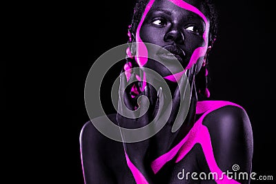 Neon colors. Pink and black body paint. Woman with face art. Young girl with colorful bodypaint. An amazing afro Stock Photo