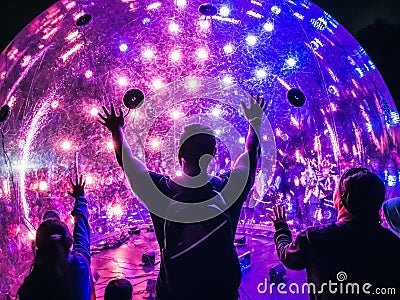 Neon Light Ball with Silhouette People Editorial Stock Photo