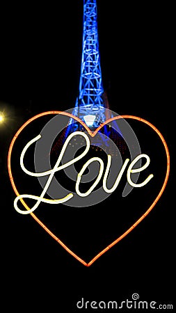 Neon lights of word Love with heart symbol and the Melbourne Arts Centre Spire illuminated in blue Editorial Stock Photo