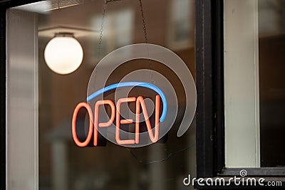 A neon open sign hanging in a window. Editorial Stock Photo