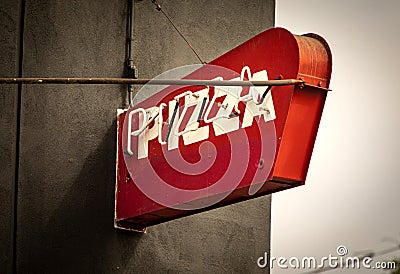 Neon red sign with white letters on a black wall stating pizza Editorial Stock Photo