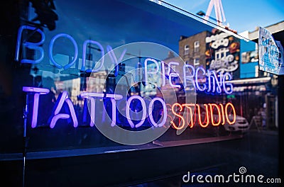 Neon sign in central London with Body Piercing Tattoo Editorial Stock Photo