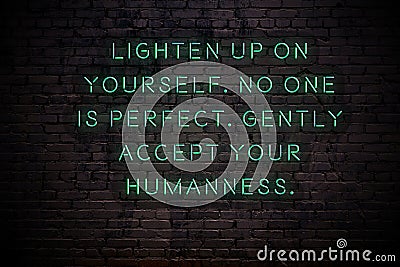 Neon sign with wise quote on brick wall in the darkness Stock Photo