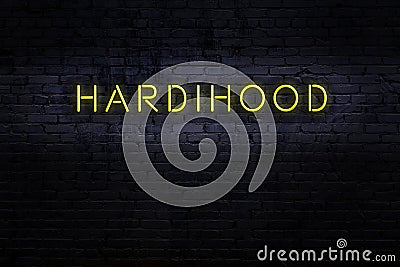 Neon sign. Word hardihood against brick wall. Night view Stock Photo