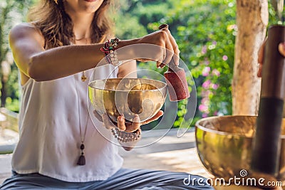 Nepal Buddha copper singing bowl at spa salon. Young beautiful woman doing massage therapy singing bowls in the Spa Stock Photo