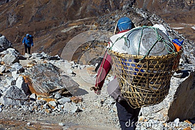 Nepalese Porter carrying Basket with rural household goods Stock Photo