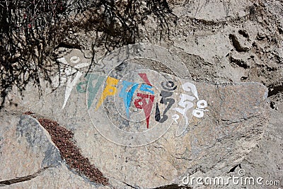 Nepalese religious symbol writing on a rock Stock Photo