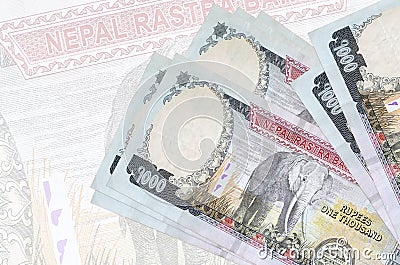 1000 Nepalese rupees bills lies in stack on background of big semi-transparent banknote. Abstract presentation of national Stock Photo