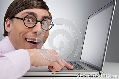 Nerd at the computer. Side view of young nerd man working at the Stock Photo