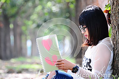 Nerd Girl Reading the Book of Loving Heart Stock Photo