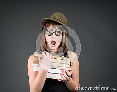 Nerd girl studying. Education. Student in funny glasses with books on grey. Stock Photo