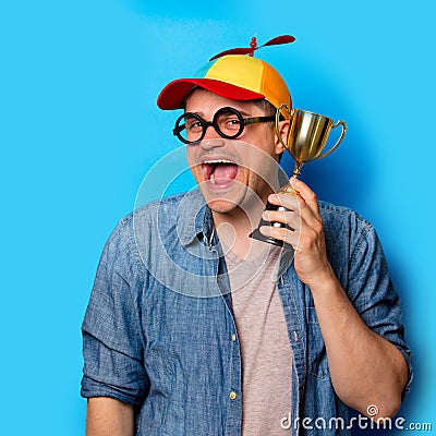 Nerd man with noob hat holding an golden cup Stock Photo