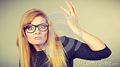 Nerdy woman in eyeglasses being confused Stock Photo