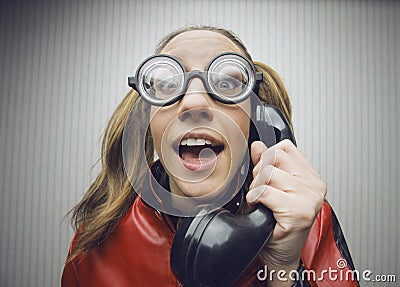 Nerdy woman speaking on a black rotary vintage phone Stock Photo