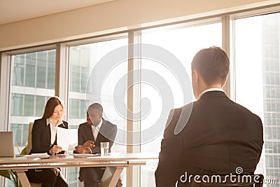 Nervous applicant waiting on chair for interview result, rear vi Stock Photo