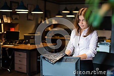 Nervous breakdown at work. Business woman freaks out and breaks the computer in the office Stock Photo