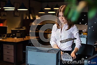 Nervous breakdown at work. Business woman freaks out and breaks the computer in the office Stock Photo