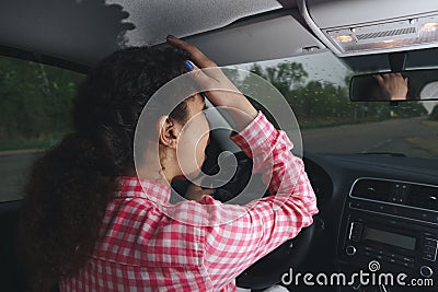 Nervous female driver sits at wheel, has worried expression as afraids to drive car by herself for first time Stock Photo