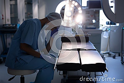 Nervous female surgeon sitting in operation room at hospital Stock Photo
