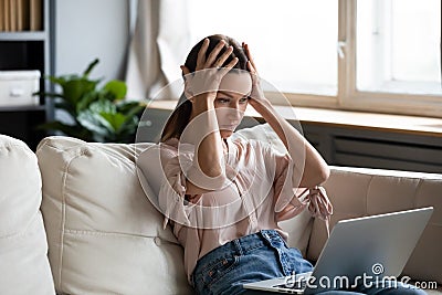 Nervous frustrated young woman looking at computer screen. Stock Photo