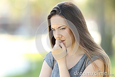 Nervous girl biting nails outside Stock Photo