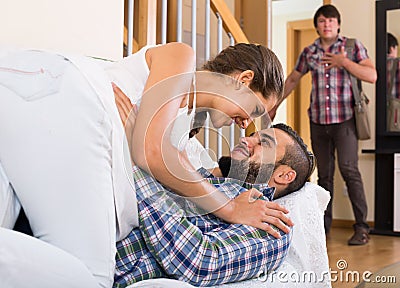 Nervous husband watching flirting spouse Stock Photo