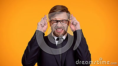 Nervous man in business suit crossing fingers for good luck, hoping to win Stock Photo