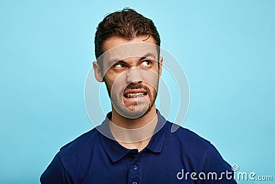 Nervous man in T-shirt snapping, looking at copy space Stock Photo