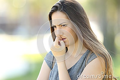 Nervous woman biting nails outdoors Stock Photo