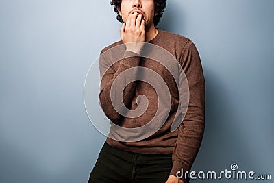 Nervous young man biting his nails Stock Photo