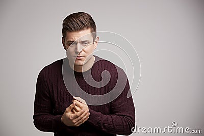 Nervous young white man rubbing his hands looking away Stock Photo