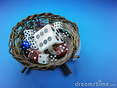Nest with colored dice inside , on blue background Stock Photo