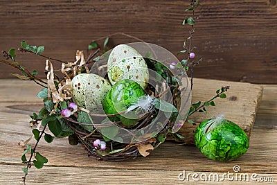 Nest with colored Easter eggs on wooden background Stock Photo