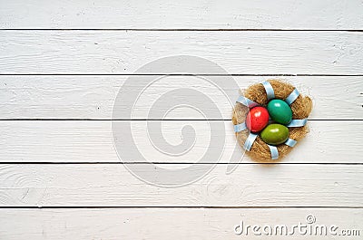 Nest colored eggs wreath on white wooden planks background Stock Photo