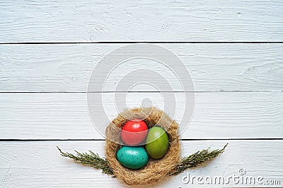 Nest colored eggs wreath on white wooden planks background Stock Photo