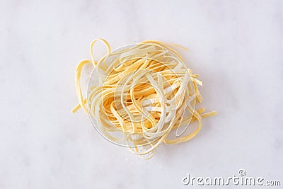 Fresh linguine pasta, top view against white marble Stock Photo