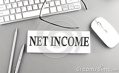 NET INCOME text on paper with keyboard on grey background Stock Photo