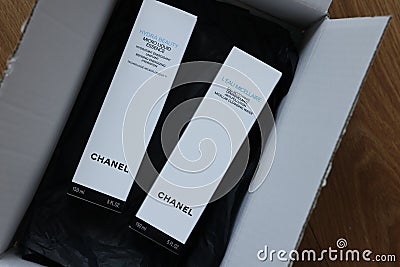 NETHERLANDS, LEIDEN - JULY 12, 2022: Chanel micellar water and micro liquid essence in box on wooden table, top view Editorial Stock Photo