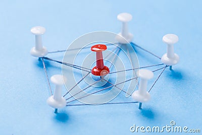 Network with red and white pins and string, An arrangement of colorful pins linked together with string on a blue background Stock Photo
