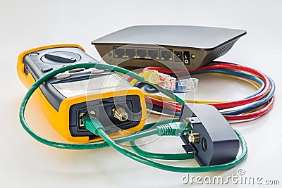 Network tester and small switch with various color RJ45 cables c Stock Photo