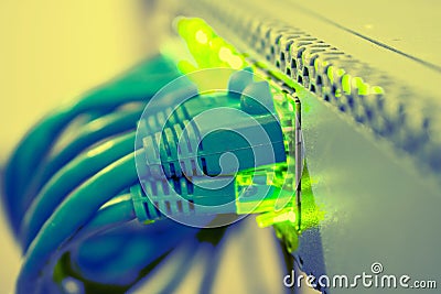 The network wires are connected to the managed switch. Green indication on ports of Internet equipment. A bunch of blue patchcords Stock Photo