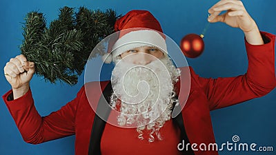 Neues Jahr 2019, Mann wie eine Sankt mit Weihnachtsbaum und rotes Ballflitterspielzeug, auf blauem Hintergrund stock video Neues Jahr 2019, Mann wie eine Sankt mit Weihnachtsbaum und rotes Ballflitterspielzeug, auf blauem Hintergrund stock video