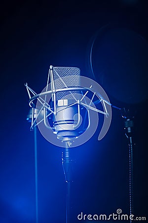 Neumann TLM 102 studio recording microphone with a spotlight on it Stock Photo