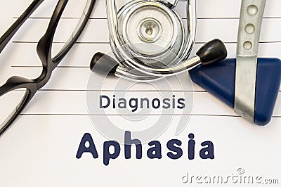 Neurological diagnosis of Aphasia. Neurological hammer, stethoscope and doctor`s glasses lie on doctor workplace on sheet of noteb Stock Photo