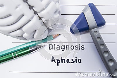 Neurological diagnosis of Aphasia. Neurological reflex hammer, shape of the brain, pen and pencil the lying on a medical report, l Stock Photo