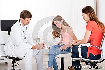 Neurologist Examining Knee Reflex On Girl Stock Photo