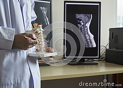 A neurosurgeon pointing at cervical spine model Stock Photo