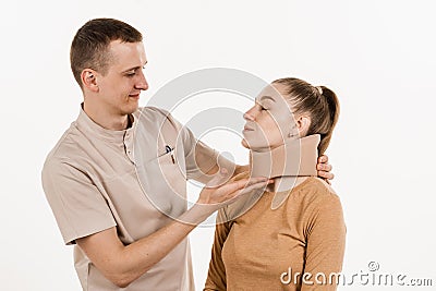 Neurosurgeon puts cervical soft collar or neck brace bandage on young woman to support and immobilize neck or for treat Stock Photo